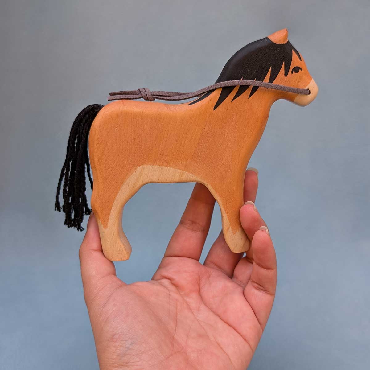 Caballo de madera, juguete Montessori artesanal para estimular la imaginación infantil. Referencia de tamaño en mano