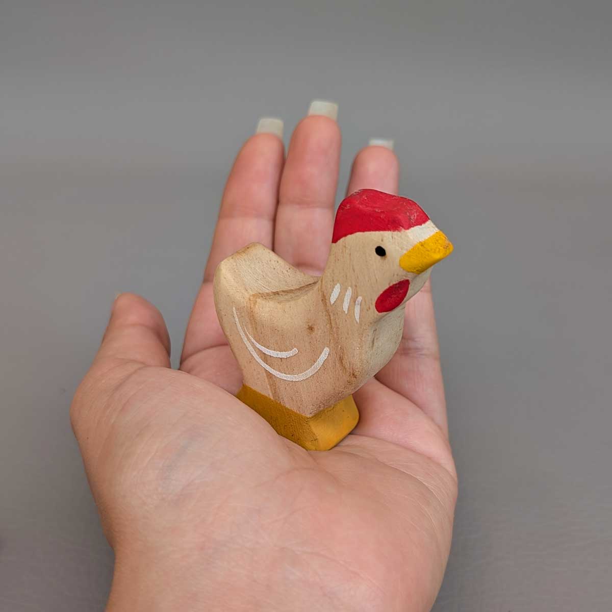 Gallina Montessori de madera, juguete artesanal para juego libre y sensorial. Referencia de tamaño en mano