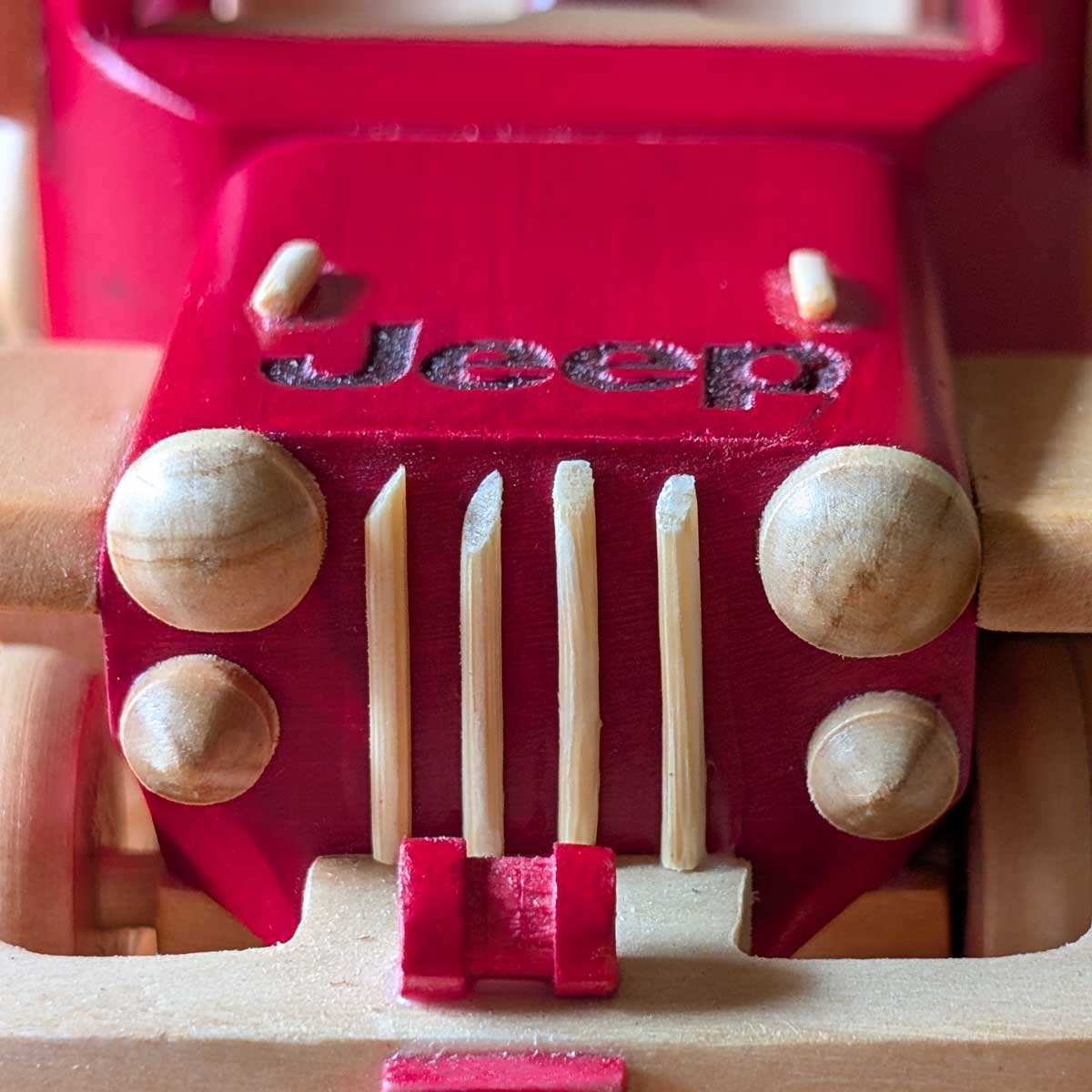 Modelo Jeep Willys deportivo color rojo de madera, ideal para coleccionistas y amantes de lo artesanal. Foto de detalle bómper