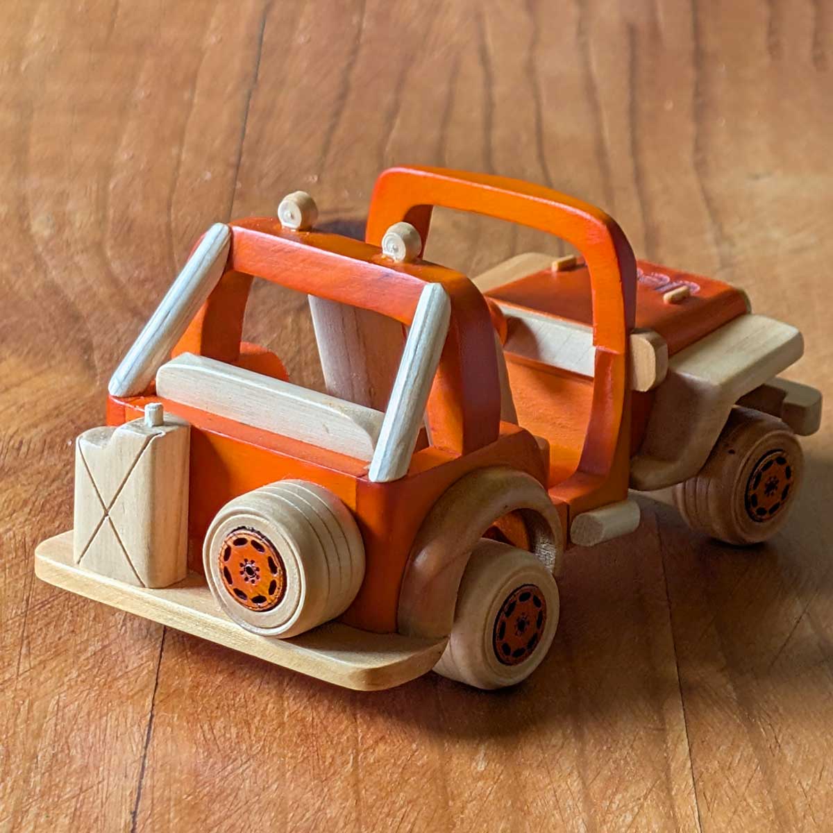 Modelo Jeep Willys deportivo color naranja de madera, ideal para coleccionistas y amantes de lo artesanal. Vista trasera