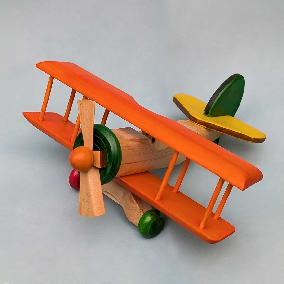 Avión biplano de madera multicolor, juguete artesanal para niños que estimula la imaginación. Color de alas naranja