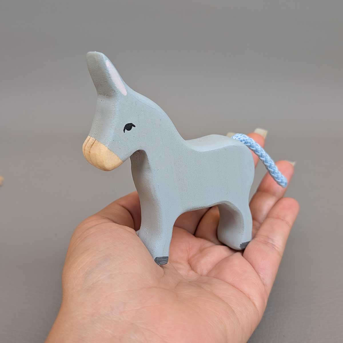 Burro Montessori de madera, juguete artesanal para juego libre y sensorial. Referencia de tamaño en mano