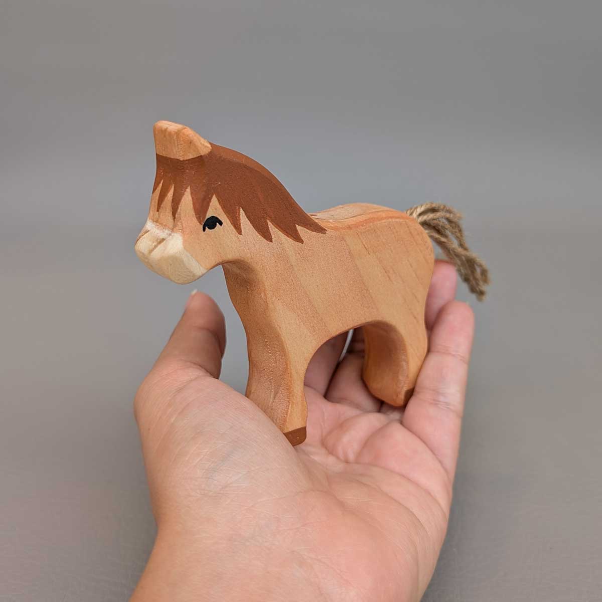 Caballo Montessori pequeño de madera, juguete artesanal para juego libre y sensorial. Referencia de tamaño en mano