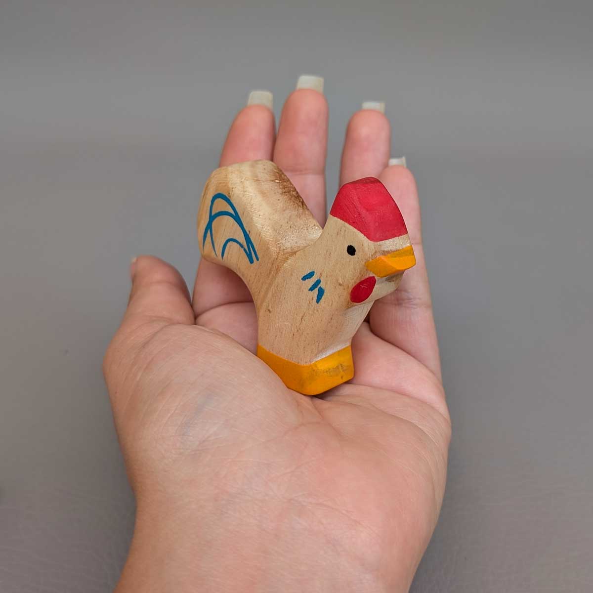 Gallo Montessori de madera, juguete artesanal para juego libre y sensorial. Referencia de tamaño en mano