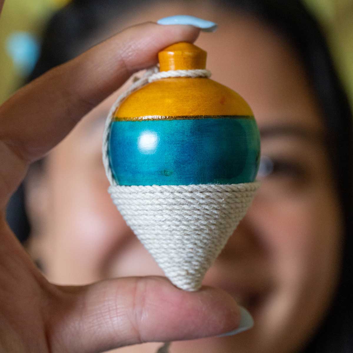 Trompo de madera artesanal, juego tradicional colombiano que desarrolla coordinación y precisión