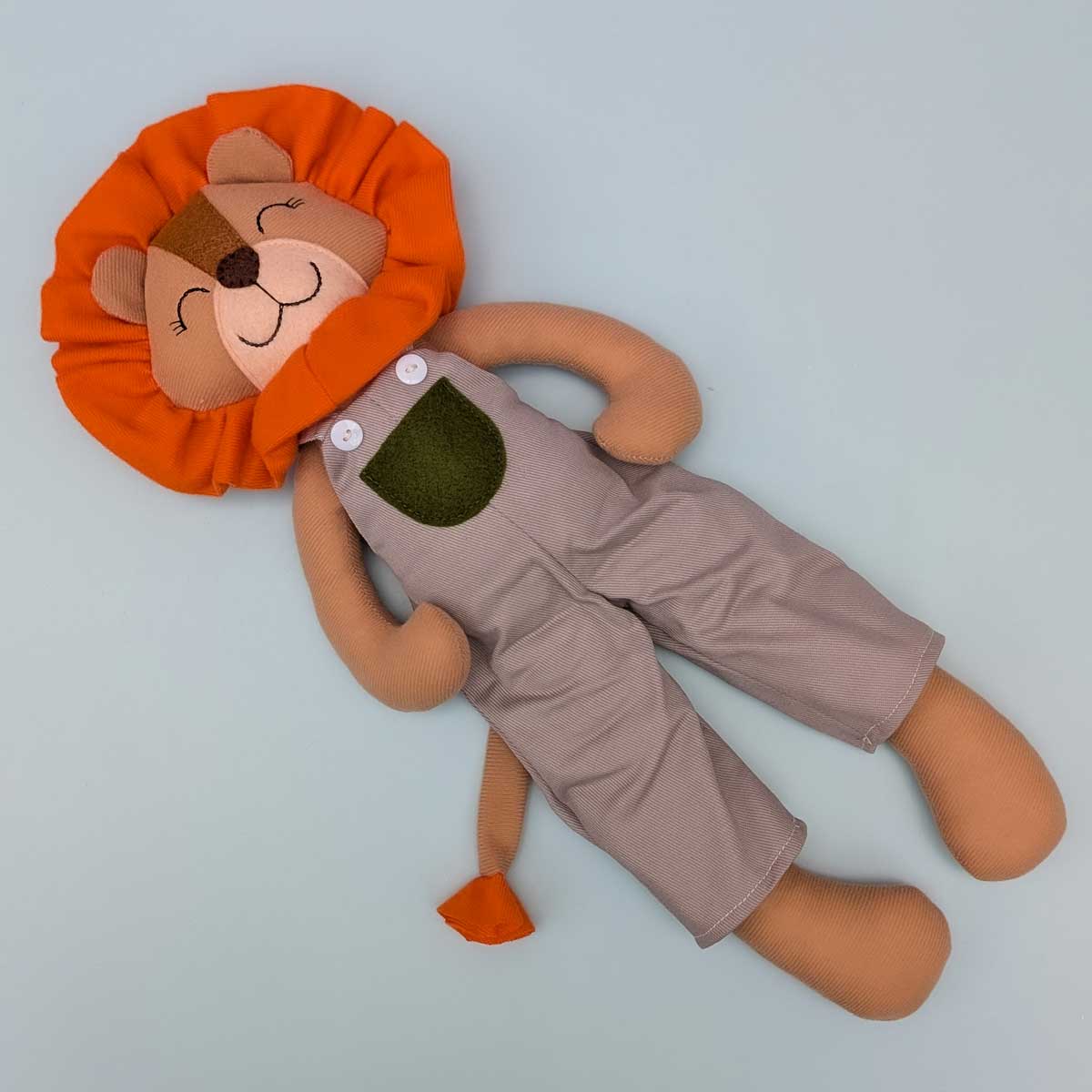 Peluche león hecho a mano en Colombia, ideal para estimular el afecto y el juego en niños. Imagen peluche de león cuerpo completo. Vestido color gris