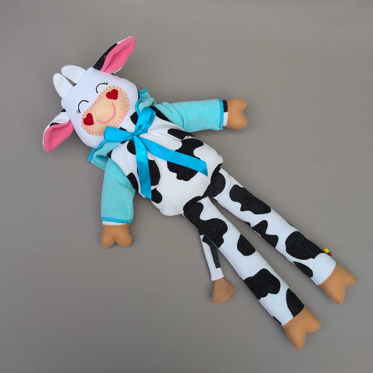 Peluche vaca Lola, con saco turquesa, hecho a mano en Colombia, ideal para estimular los sentidos de los niños